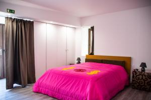 1 cama rosa grande en un dormitorio con en DOURO FAMILY 2BD Apartment, en São João da Pesqueira