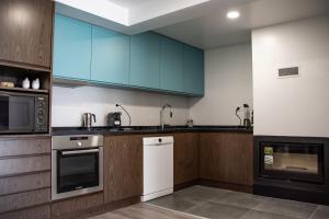 cocina con armarios azules y nevera blanca en DOURO FAMILY 2BD Apartment, en São João da Pesqueira
