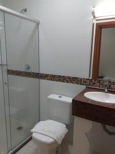 a bathroom with a shower and a toilet and a sink at Hotel Praça da Matriz in Porto Alegre