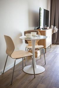 a white table with two chairs and a tv at Järvevaatega studio apartment in Viljandi
