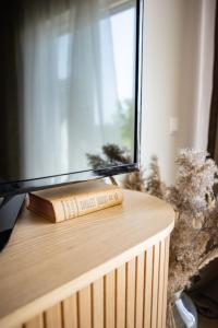 a book sitting on top of a table next to a window at Järvevaatega apartment in Viljandi