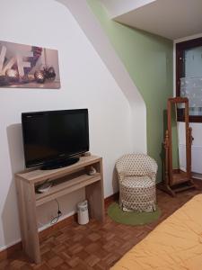 a living room with a tv and a chair at chambres d'hôtes du clos du roi in Pontorson