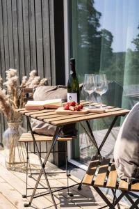 a table with a bottle of wine and wine glasses at Järvevaatega apartment in Viljandi