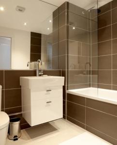 a bathroom with a sink and a shower and a toilet at Barbican Serviced Apartments in London