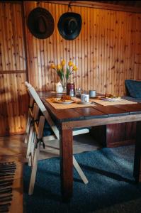 un tavolo in legno con sedie e fiori di The Happy Cottage a Ioannina