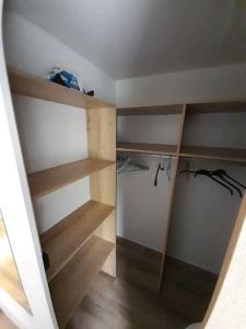 an empty closet with wooden shelves in a room at 692F Emplacement luxe à la Réserve 4* in Gastes
