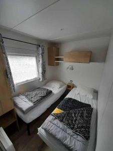 a small room with two beds and a window at 692F Emplacement luxe à la Réserve 4* in Gastes