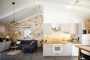 eine Küche und ein Wohnzimmer mit einer Steinmauer in der Unterkunft Villa Pearl of Kali - seafront in Kali
