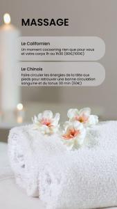 Una toalla blanca con flores encima. en Le Raphaël, en Le Puy en Velay