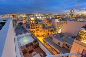 a view of a city at night at Beautiful 3BR Triplex penthouse with Hot-Tub by 360 Estates in Il-Gżira