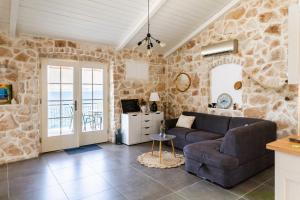 ein Wohnzimmer mit einem Sofa und einer Steinmauer in der Unterkunft Villa Pearl of Kali - seafront in Kali
