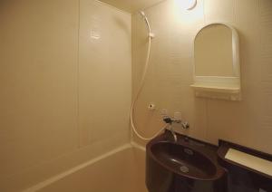 La salle de bains est pourvue d'un lavabo et d'un miroir. dans l'établissement 抹茶庵世田谷東京 Matcha-An Setagaya Tokyo, à Tokyo