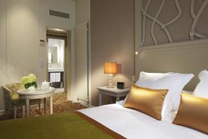 a bedroom with a bed and a table with a lamp at Splendid Etoile in Paris