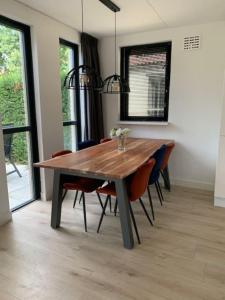 - une table en bois dans une chambre entourée de chaises dans l'établissement Groenlake Villa 16 - 6 persoons vakantie bungalow, à Ewijk