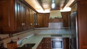 a kitchen with wooden cabinets and a stainless steel refrigerator at Casa la Felguerina in La Felguerina +8 photos