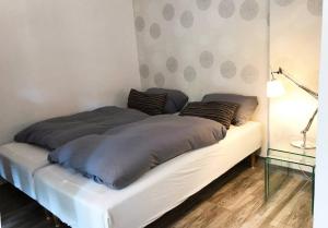 a bed with two pillows on it in a room at Designer Central Apartment with Parking & Terrace in Berlin