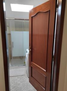 a wooden door in a bathroom with a toilet at Casa Câmara in Arco da Calheta