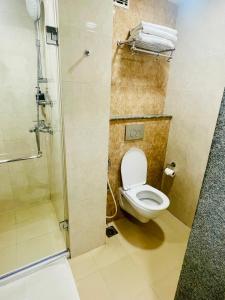 a bathroom with a toilet and a shower at Ginger Trivandrum in Kazhakuttam