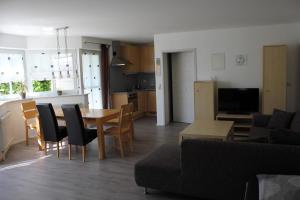 een woonkamer en een keuken met een tafel en stoelen bij Ferienwohnung Bucher in Tettnang