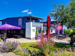 ein Gebäude mit lila Sonnenschirmen in einem Garten in der Unterkunft Peterchens Mondfahrt - Wasserkuppe in Gersfeld