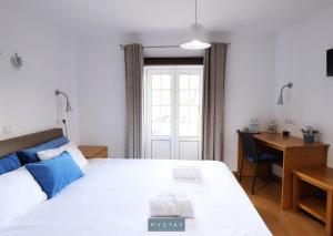 a bedroom with a white bed and a desk and a desk at MyStay - Casa Miná in Montalegre