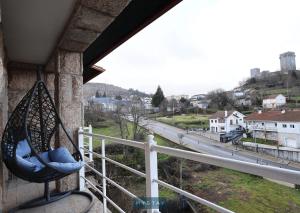 un columpio en un balcón con vistas a la calle en MyStay - Casa Miná, en Montalegre