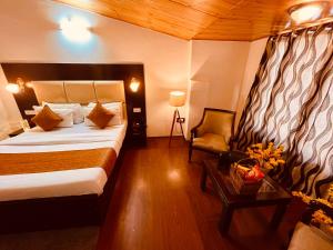 a hotel room with a bed and a chair at Hotel The North Wind in City Center, Manali in Manāli