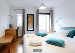 1 dormitorio con cama con almohadas verdes y escritorio en MyStay - Casa Miná, en Montalegre