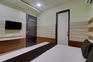 a bedroom with a bed and a flat screen tv at Collection O The Legend Hotel, Hisar in Hisār