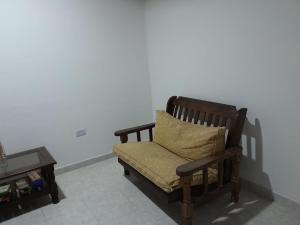 eine Holzbank mit einem Kissen auf dem Tisch in der Unterkunft Casa Privada 2 habitaciones, amueblada Centro Necochea in Necochea