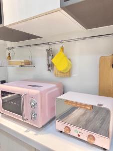 un horno tostador rosa sentado en una encimera de cocina en Hi House en Toucheng