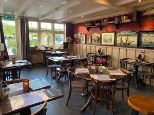 een restaurant met tafels en stoelen in een kamer bij Hotel Café Restaurant Heineke in Loosdrecht