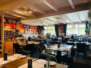 een restaurant met tafels en stoelen en mensen erin bij Hotel Café Restaurant Heineke in Loosdrecht