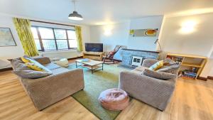 a living room with two chairs and a fireplace at Rockham Bay View - Sleeps 6 Mortehoe in Mortehoe