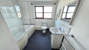 a bathroom with a sink and a tub and a toilet at Rockham Bay View - Sleeps 6 Mortehoe in Mortehoe +15 photos