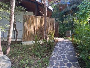 un passaggio pedonale di fronte a una casa con recinzione di Suitree Experience Hotel a Guanacaste