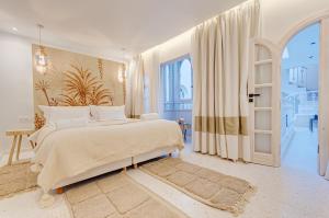 una camera bianca con un grande letto e una porta aperta di Riad K-white a Marrakech