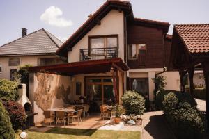 a house with a patio with a table and chairs at Penzion Harmonia in Liptovský Mikuláš