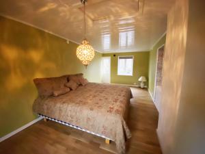 een slaapkamer met een bed en een kroonluchter bij Holiday home in central Hoganas in Höganäs