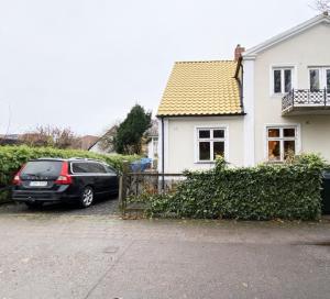 een auto geparkeerd voor een wit huis bij Holiday home in central Hoganas in Höganäs