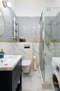 uma casa de banho com um lavatório e um chuveiro. em WAWELOVE spacious 3 bedroom apt 1 min to Main Sq! na Cracóvia