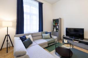 uma sala de estar com um sofá e uma televisão em WAWELOVE spacious 3 bedroom apt 1 min to Main Sq! na Cracóvia