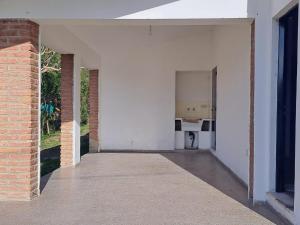 um quarto vazio com paredes brancas e uma parede de tijolos em Chalet Abuela Betty em Tanti