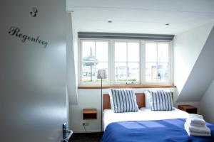 a bedroom with a bed and a window at Hotel Café Restaurant Heineke in Loosdrecht