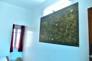 a painting hanging on a wall in a room at Suryas Rooms in Varkala