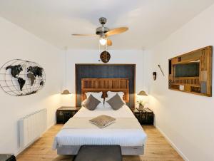 Chambres d'Hôtes La Filature في سانت كونتان: غرفة نوم بسرير ومروحة سقف