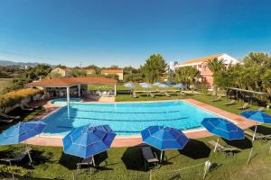 - une piscine avec des parasols et des chaises bleus dans l'établissement Olive Τrees Garden, à Lixouri