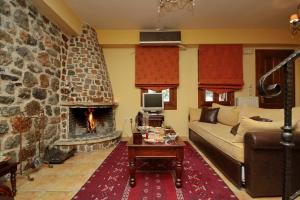 a living room with a couch and a fireplace at Menalia Villas & Suites ΚΤΗΜΑ ΚΟΥΜΠΟΥΡΗ in Levidi