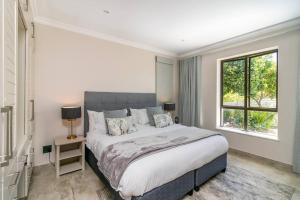 - une chambre avec un grand lit et une fenêtre dans l'établissement Pezula - Magical Seaside breakway on Pezula 4 bed, à Knysna