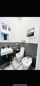 a bathroom with a white toilet and a sink at Rodinó rooms in Naples